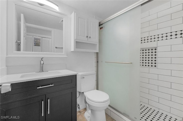 bathroom featuring a shower stall, toilet, and vanity