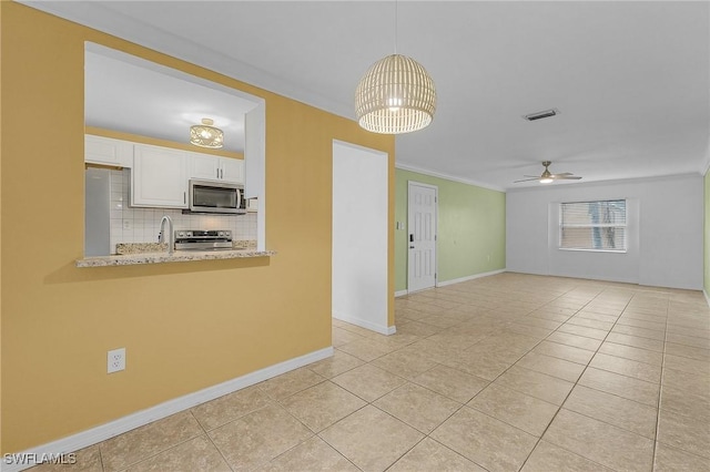 interior space with light tile patterned floors, visible vents, baseboards, a sink, and ceiling fan with notable chandelier