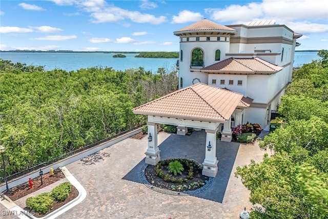 exterior space with decorative driveway and a water view