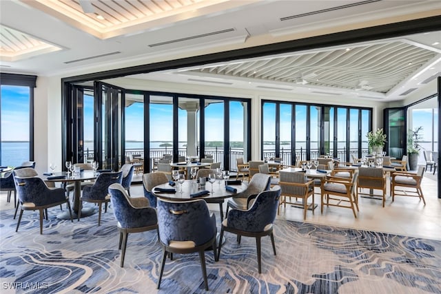 dining area featuring a wealth of natural light, a wall of windows, and a water view