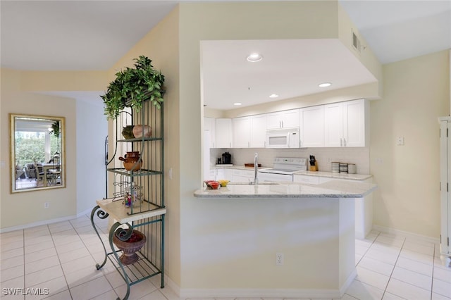 kitchen with white cabinetry, sink, light tile patterned floors, light stone counters, and white appliances