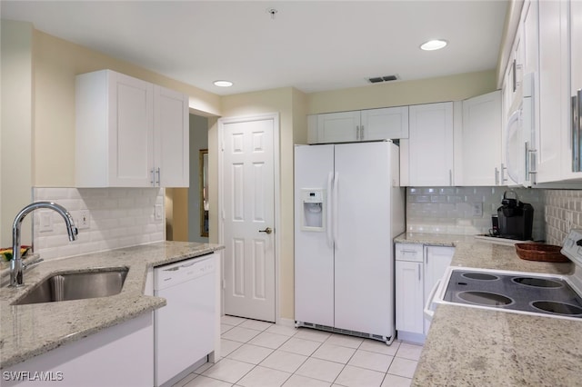 kitchen with light tile patterned flooring, sink, white appliances, decorative backsplash, and white cabinets