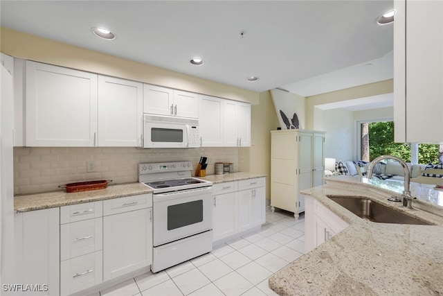 kitchen with white cabinetry, sink, white appliances, and light stone countertops