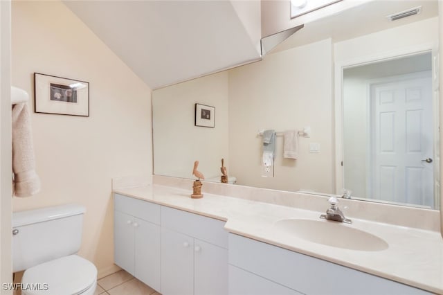 bathroom with vanity, lofted ceiling, tile patterned floors, and toilet