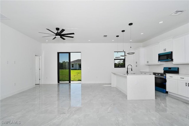 kitchen featuring electric range, visible vents, an island with sink, open floor plan, and black microwave