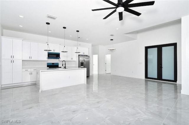 kitchen featuring stainless steel appliances, a sink, visible vents, white cabinets, and open floor plan