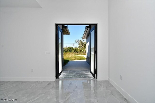 doorway with marble finish floor and baseboards