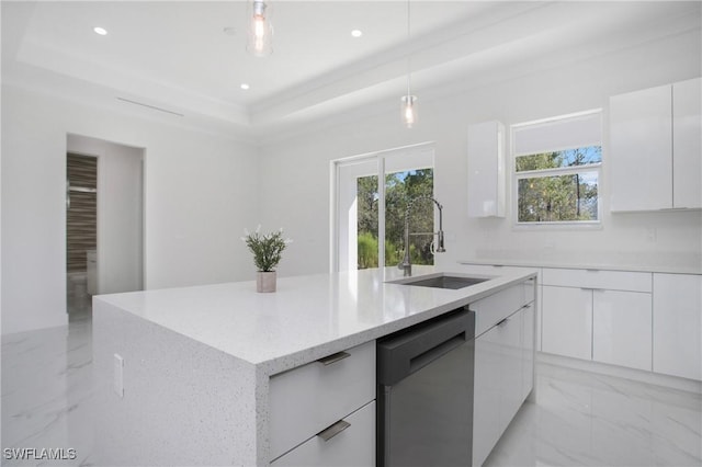 kitchen featuring pendant lighting, sink, stainless steel dishwasher, a tray ceiling, and white cabinetry