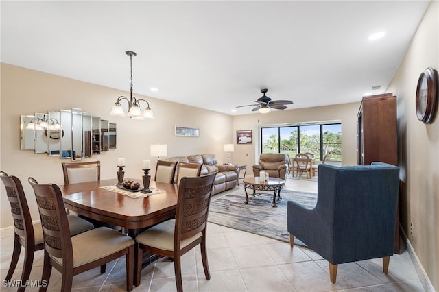 dining space with ceiling fan with notable chandelier and light tile patterned flooring