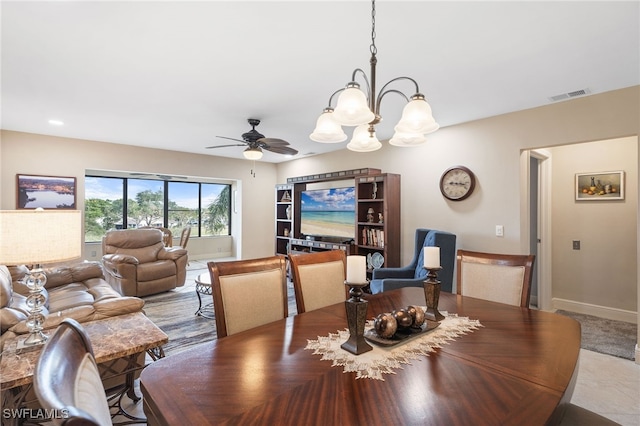 dining area featuring ceiling fan with notable chandelier