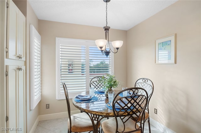 dining area featuring light tile patterned floors, a textured ceiling, and a notable chandelier