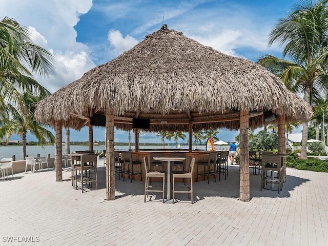 view of home's community featuring a water view, a bar, and a patio