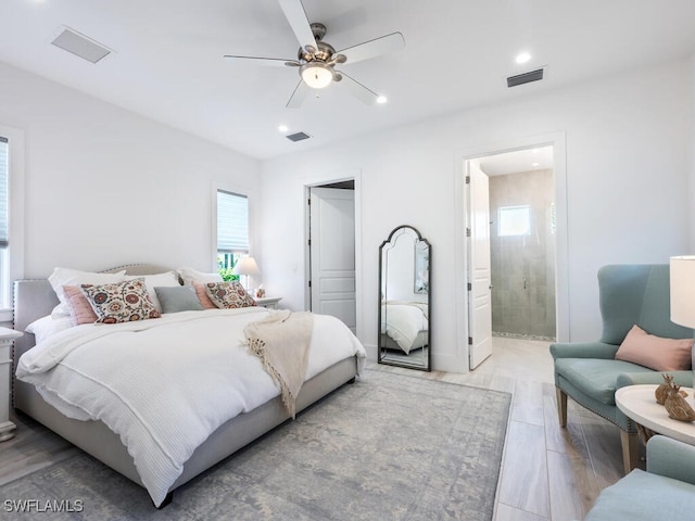 bedroom featuring ceiling fan, light wood-type flooring, and ensuite bath