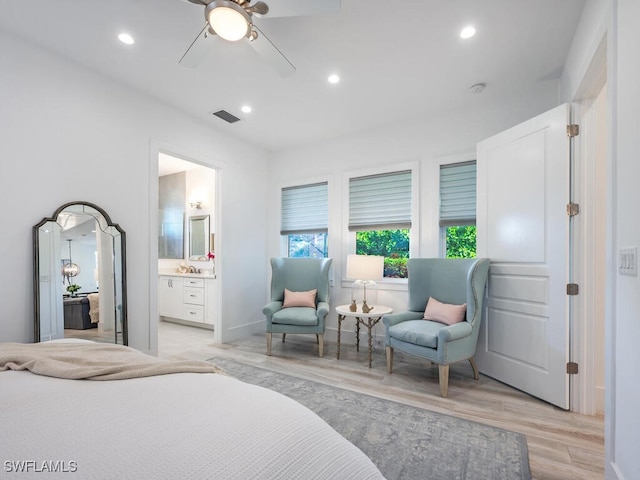 bedroom featuring ceiling fan, ensuite bath, and light wood-type flooring