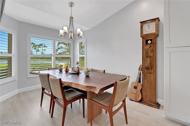 dining space with a chandelier, lofted ceiling, and light hardwood / wood-style floors