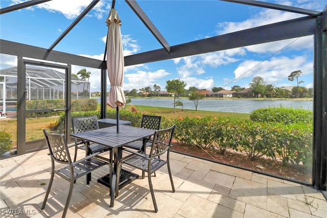 view of patio / terrace featuring glass enclosure and a water view