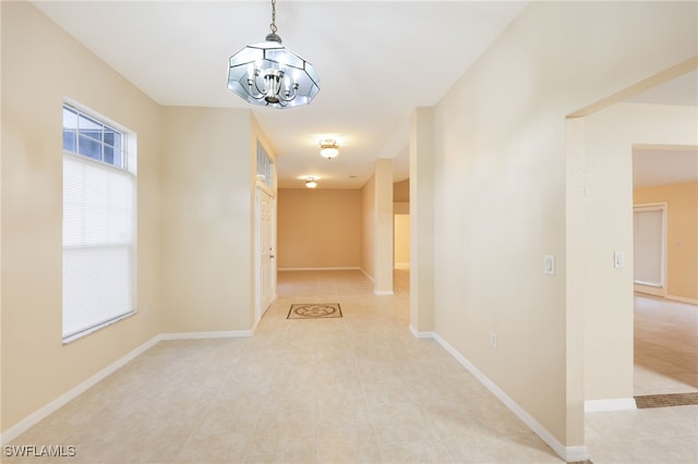 hallway featuring light tile patterned floors and a chandelier