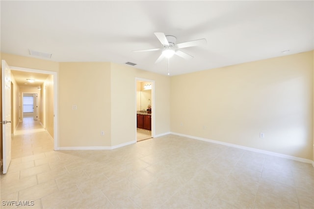 spare room with ceiling fan and light tile patterned floors