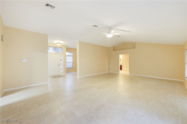 spare room featuring ceiling fan, light tile patterned flooring, and vaulted ceiling