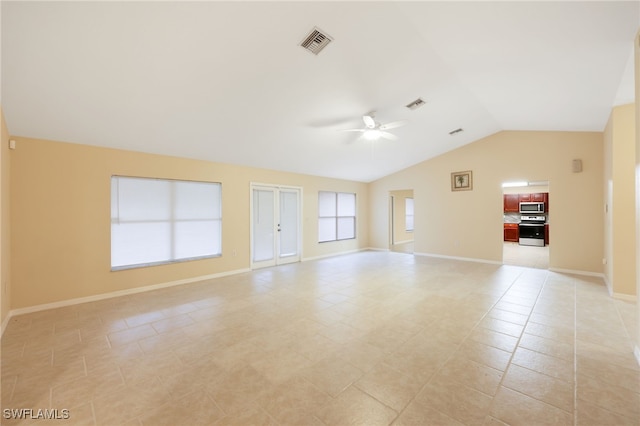 empty room featuring ceiling fan, light tile patterned floors, and vaulted ceiling