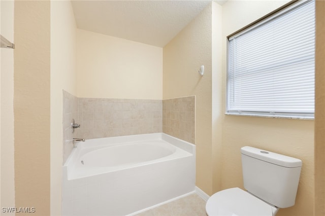 bathroom with tile patterned flooring, toilet, a bath, and a textured ceiling