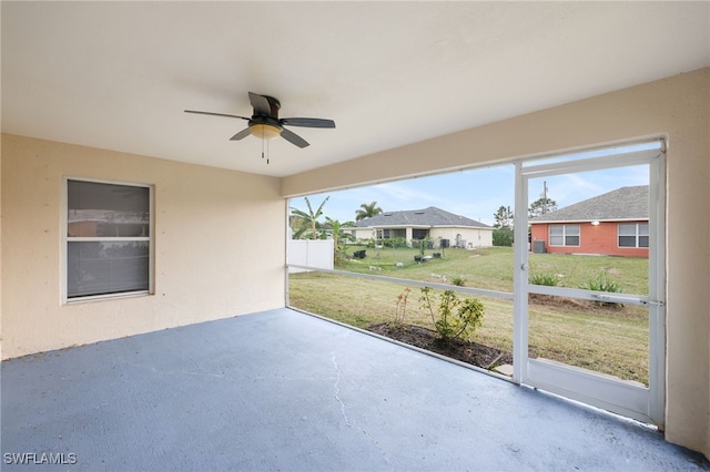 unfurnished sunroom featuring ceiling fan and a healthy amount of sunlight