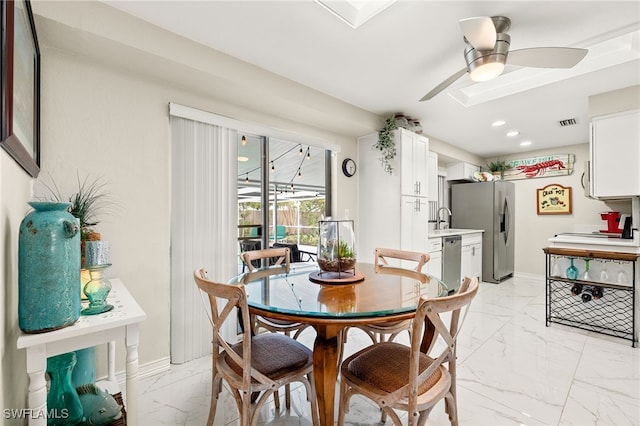 dining space featuring ceiling fan and sink