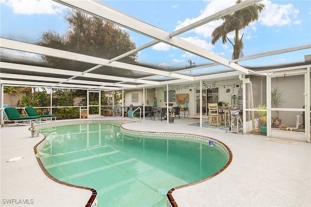 view of pool featuring glass enclosure and a patio area