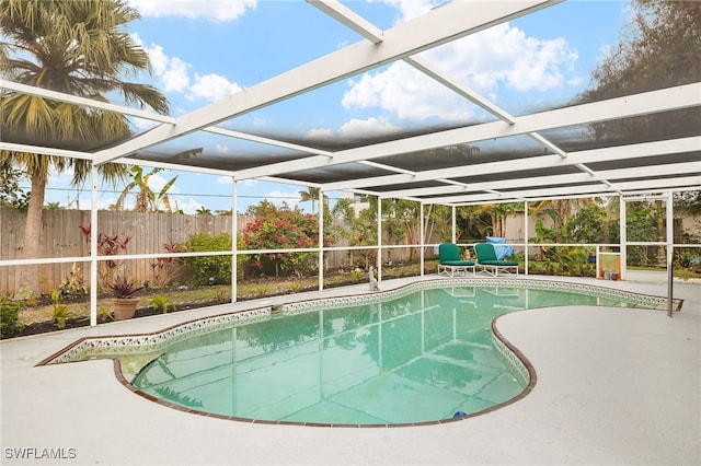 view of pool featuring glass enclosure and a patio area