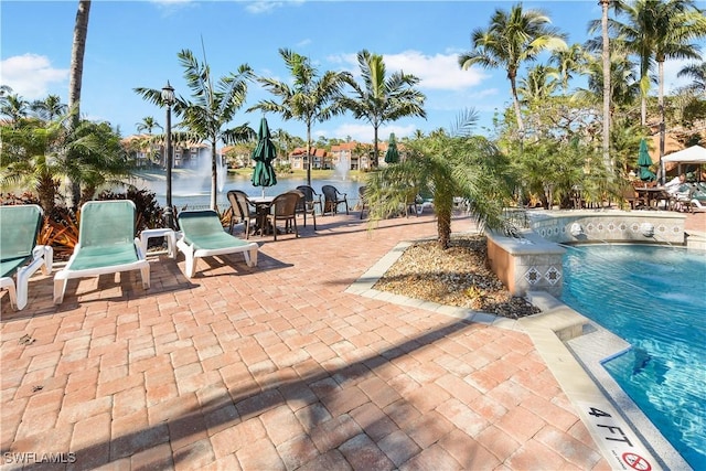 view of pool with pool water feature and a patio