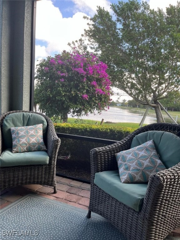 sunroom / solarium featuring a water view