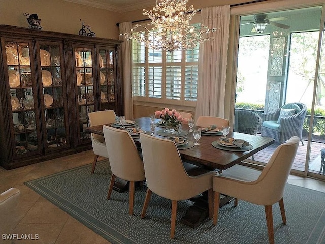 dining space featuring ceiling fan with notable chandelier, tile patterned floors, and crown molding