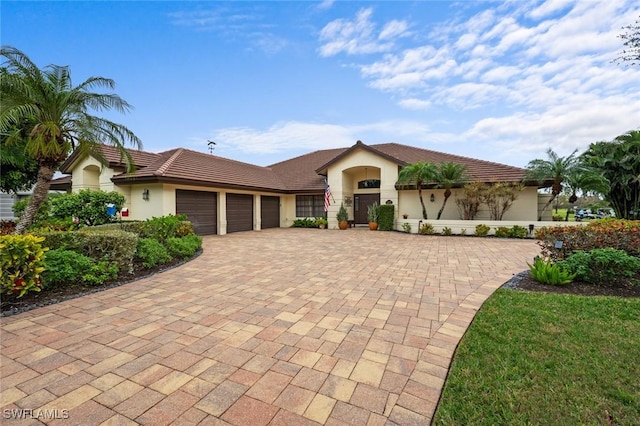 20273 Leopard Ln, Estero, FL 33928 - view of front facade with an attached garage, stucco siding, and decorative driveway