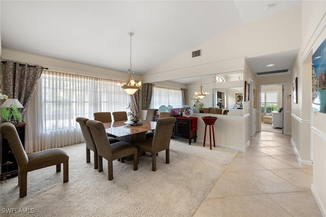 tiled dining space featuring a chandelier and vaulted ceiling