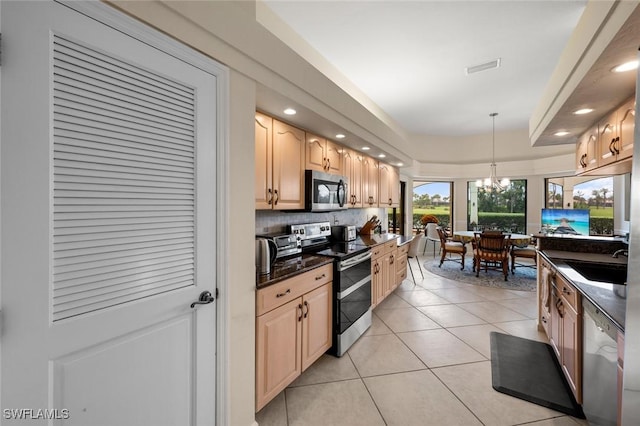 kitchen with an inviting chandelier, appliances with stainless steel finishes, tasteful backsplash, decorative light fixtures, and sink