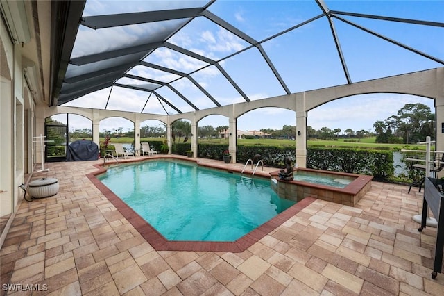 view of swimming pool featuring glass enclosure, area for grilling, a water view, an in ground hot tub, and a patio