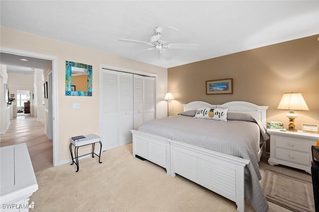 bedroom featuring light carpet, ceiling fan, and a closet