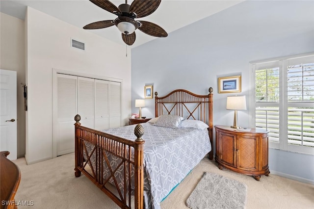 carpeted bedroom with ceiling fan and a closet