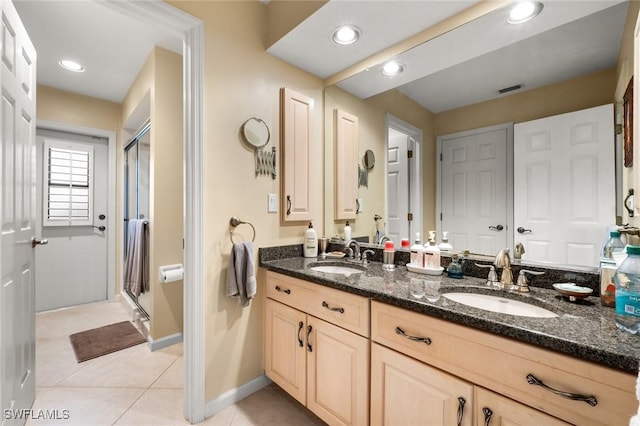 bathroom with tile patterned floors, a shower with door, and vanity