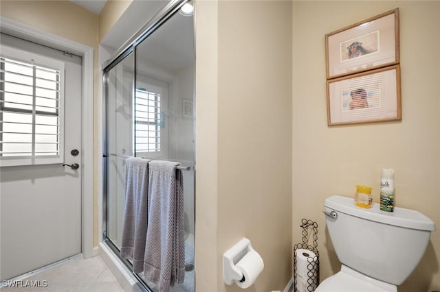 bathroom with a wealth of natural light, an enclosed shower, and toilet