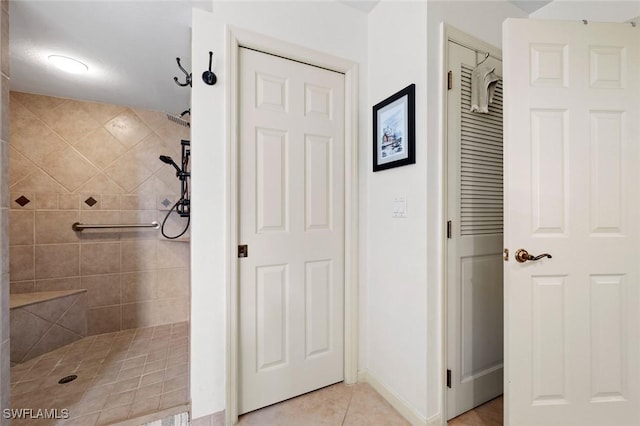 bathroom featuring tile patterned flooring and a tile shower