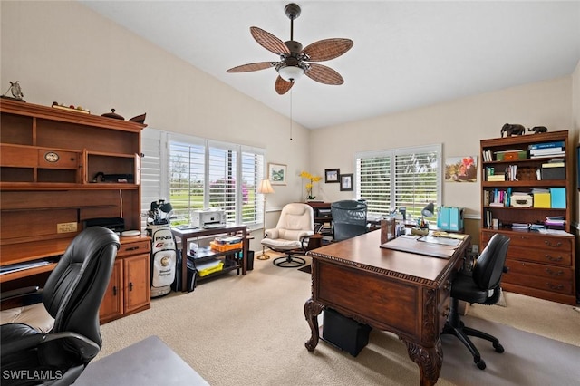 carpeted home office with ceiling fan and vaulted ceiling