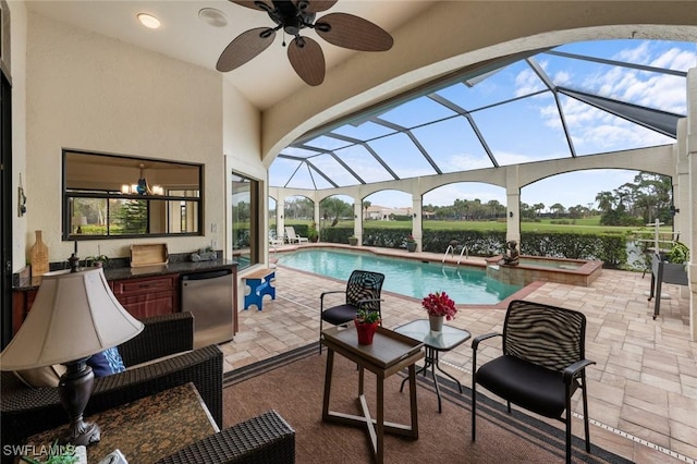 view of swimming pool with glass enclosure, a patio area, a jacuzzi, and exterior kitchen