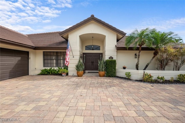 20273 Leopard Ln, Estero, FL 33928 - entrance to property featuring stucco siding, a tiled roof, an attached garage, and driveway