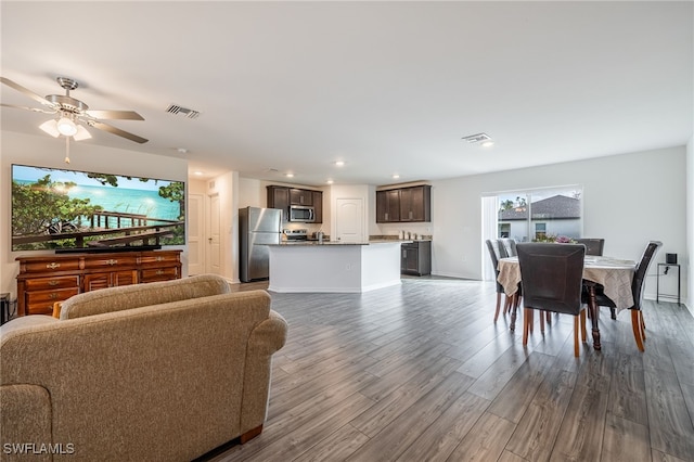 living room featuring dark hardwood / wood-style flooring and ceiling fan