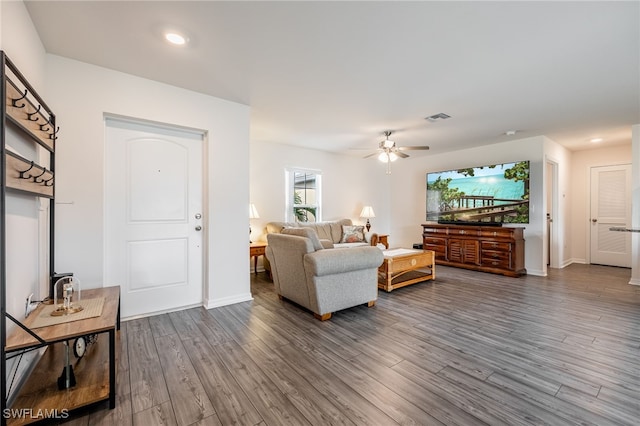 living room featuring ceiling fan and dark hardwood / wood-style floors