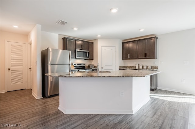 kitchen featuring dark brown cabinetry, stainless steel appliances, and a kitchen island with sink