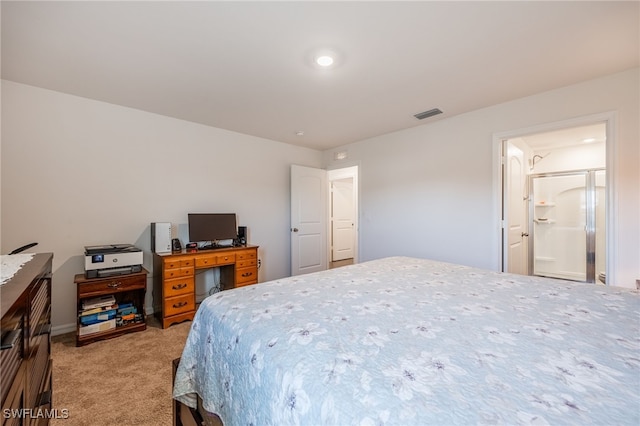 bedroom with ensuite bathroom and light colored carpet