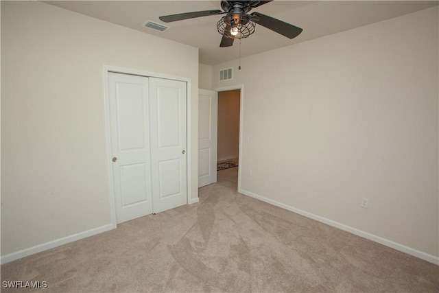 unfurnished bedroom with ceiling fan, a closet, and light colored carpet