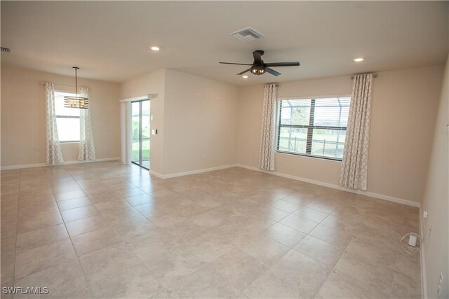 tiled empty room featuring ceiling fan and a healthy amount of sunlight